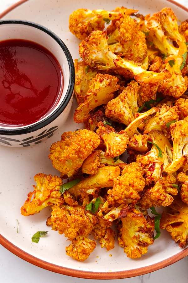 closeup air fryer roasted cauliflower with tomato sauce