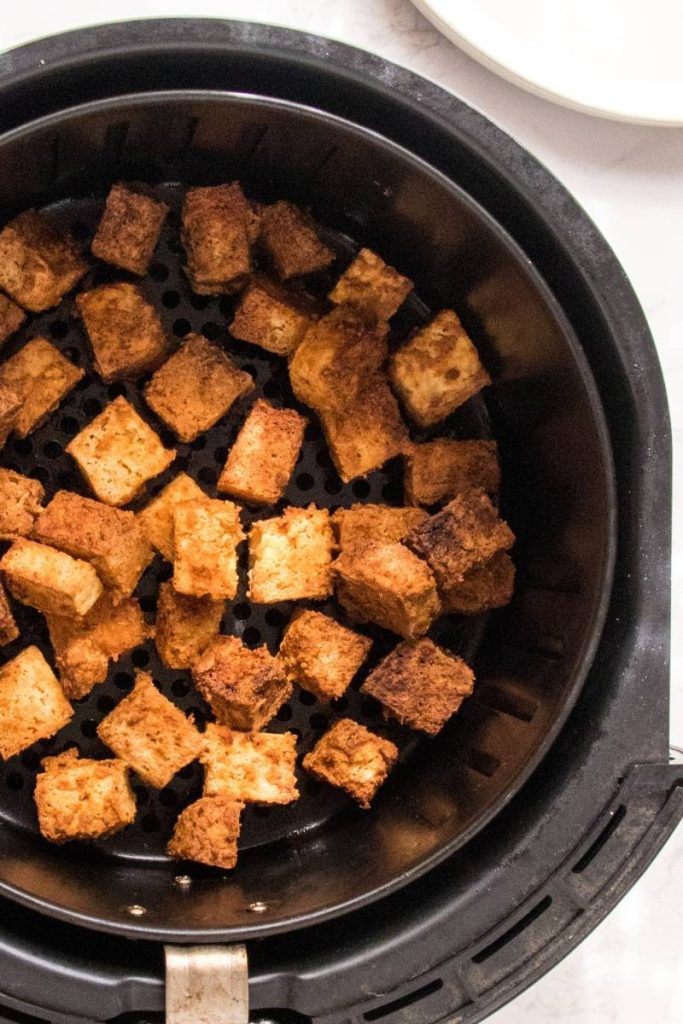 closeup to air fried tofu in black air fryer basket