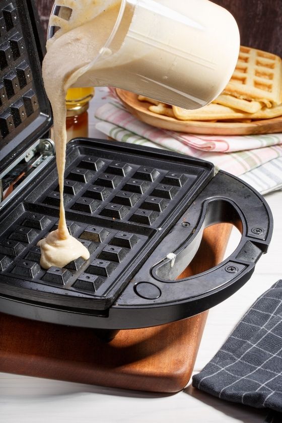 pouring waffle mixture into waffle maker healthy banana and oats waffle recipe