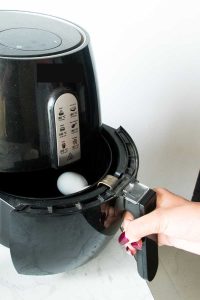 putting raw eggs into the air fryer