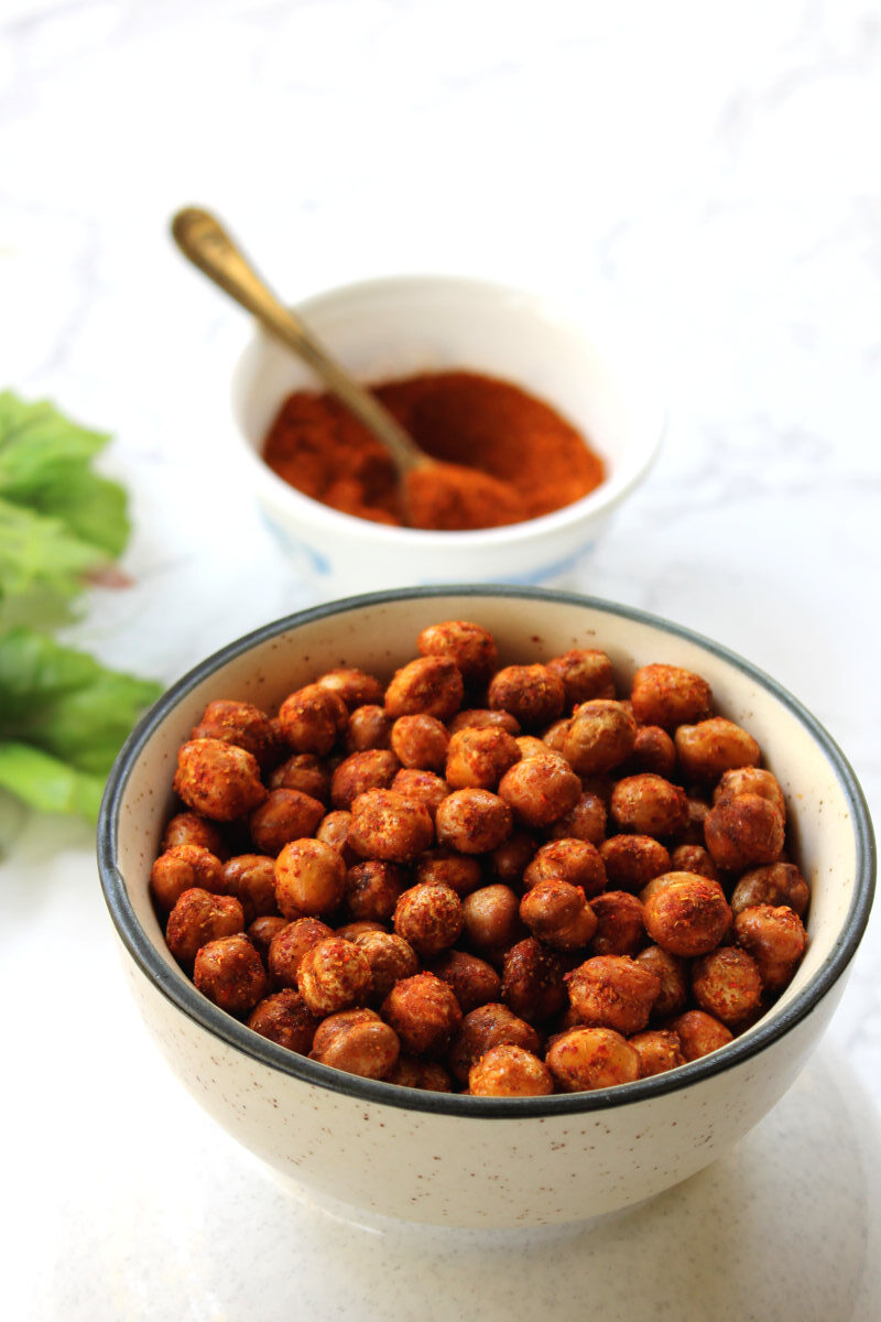 air fryer roasted chickpeas in a white bowl with a bowl of fajita seasoning