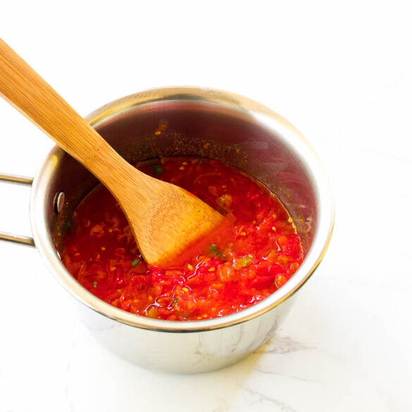 easy homemade arribbata sauce recipe in a saucepan with a wodden spatula