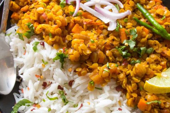 The photo shows a bowl of creamy, aromatic red lentil curry without coconut milk with a spoon and some spices on top