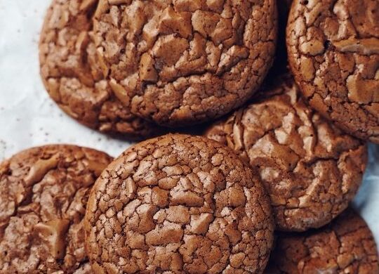 Stacks of brownie cookies on a piece of brown parchment paper