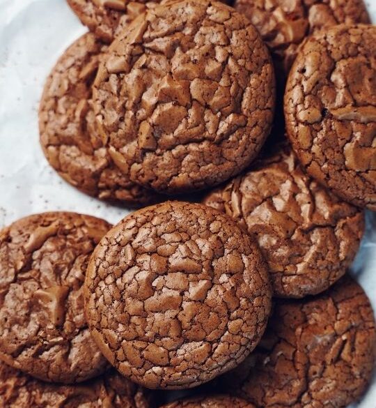 Stacks of brownie cookies on a piece of brown parchment paper