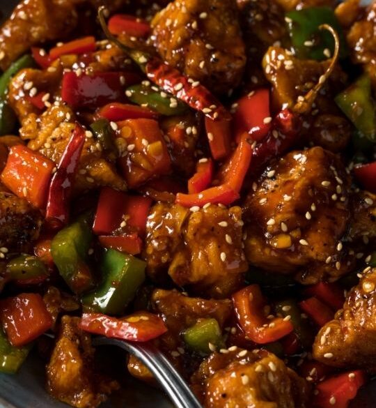 Szechuan chicken with vegetables and chili peppers in a skillet