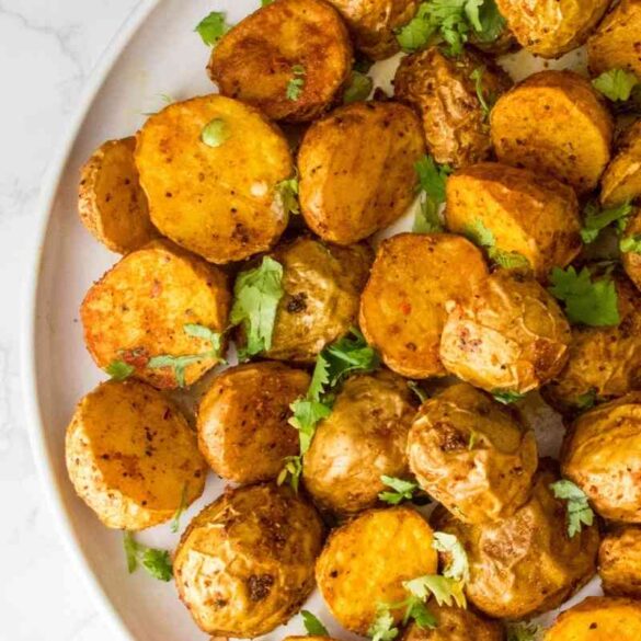 A close up of air fryer roasted baby potatoes one white plate