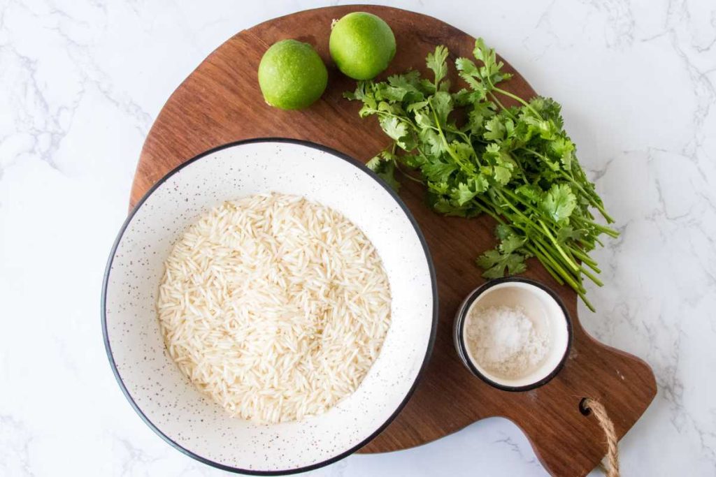 White marble countertop with bowls of Ingredients to make cilantro lime rice