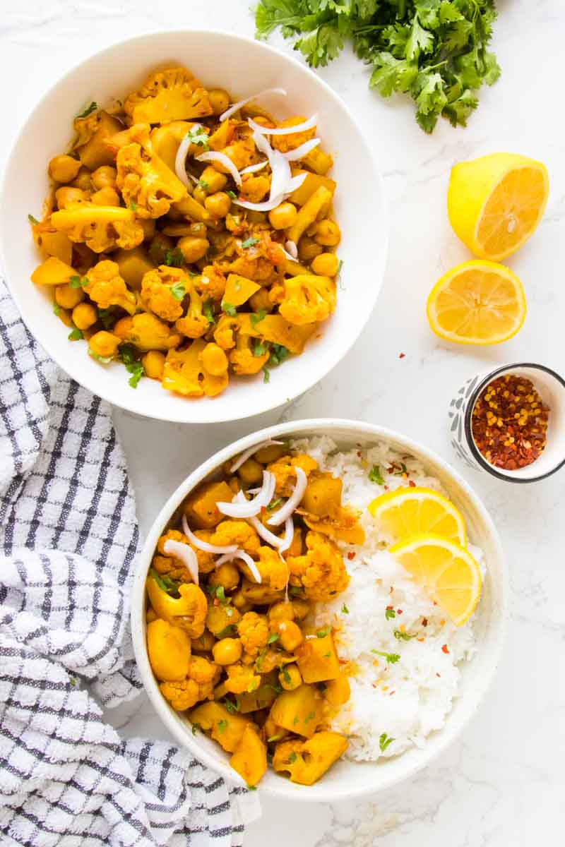 veagn cauliflower and chickpea curry with basmati rice and lemon wedges