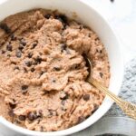 A golden spoon in a bowl of edible cottage cheese cookie dough